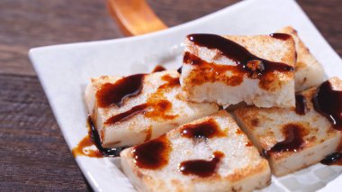 Lezzetli şalgam kekinin üzerine kara soya sosu dök restoranda geleneksel Çin turplu keki, kapat, uzayı kopyala.