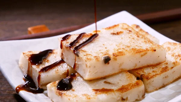 Lezzetli şalgam kekinin üzerine kara soya sosu dök restoranda geleneksel Çin turplu keki, kapat, uzayı kopyala.