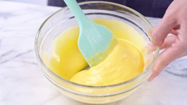 Yumurta sarısını kek hamuruna karıştırarak yeşil kauçuk spatula karıştırma aleti ile karıştırarak pürüzsüz olana kadar karıştırır ve karıştırır, kapayın, yaşam tarzınızı