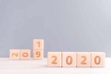 Soyut 2020, 2019 Yeni Yıl Hedef Tasarım Konsepti - ahşap masa ve pastel mavi arkaplan üzerinde tahta bloklar küp, kapat, boş kopya alanı.
