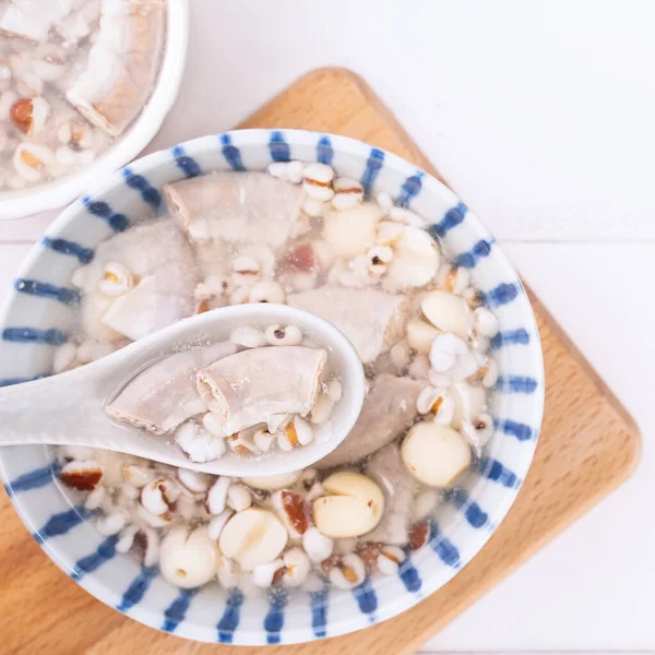 Tasty Four Tonics Herb Flavor Soup, Taiwanese traditional food with herbs, pork intestines on white wooden table, close up, flat lay, top view