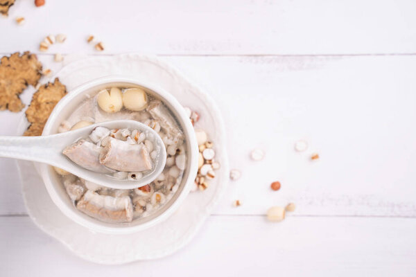 Tasty Four Tonics Herb Flavor Soup, Taiwanese traditional food with herbs, pork intestines on white wooden table, close up, flat lay, top view