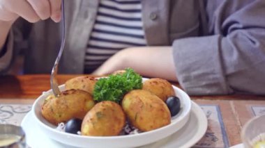 Kırpılmış manzaralı bir kadın tuzlu morina yemeği yiyor, Pasteis de Bacalhau, Bacalao, Bacallao, Macau restoranında lezzetli Portekiz yemekleri yiyor, yaşam tarzı.