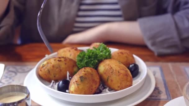 Kırpılmış Manzaralı Bir Kadın Tuzlu Morina Yemeği Yiyor Pasteis Bacalhau — Stok video