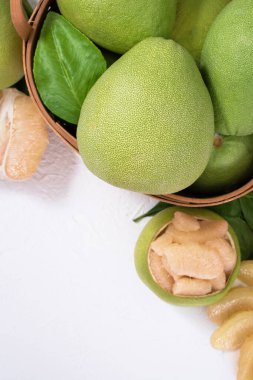 Taze pomelo, pummelo, greyfurt, bambu sepetinde beyaz çimento arka planında Shaddock. Sonbahar mevsimlik meyveler, üst manzara, düz yatış, masa üstü çekimi.