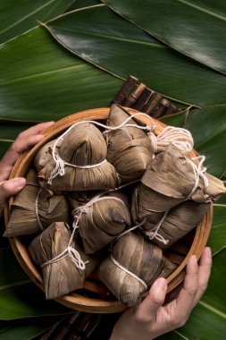 Pirinç köftesi, zongzi - Ejderha Teknesi Festivali 'nin yeşil yapraklı arka planında geleneksel Çin yemeği, Duanwu Festivali, üst manzara, düz dizayn konsepti.