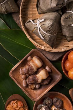 Pirinç köftesi, zongzi - Ejderha Teknesi Festivali 'nin yeşil yapraklı arka planında geleneksel Çin yemeği, Duanwu Festivali, üst manzara, düz dizayn konsepti.
