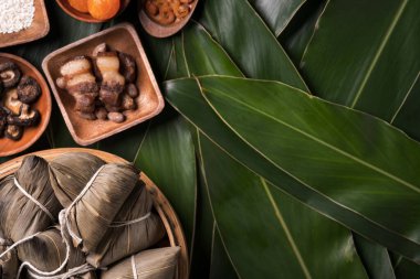Pirinç köftesi, zongzi - Ejderha Teknesi Festivali 'nin yeşil yapraklı arka planında geleneksel Çin yemeği, Duanwu Festivali, üst manzara, düz dizayn konsepti.