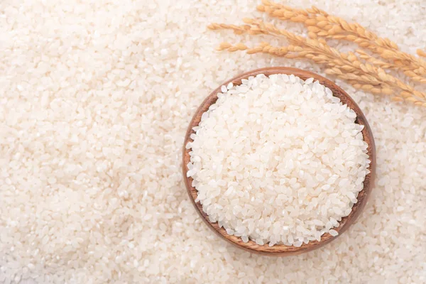 Raw rice in a bowl and full frame in the white background table, top view overhead shot, close up