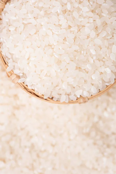 Raw rice in a bowl and full frame in the white background table, top view overhead shot, close up