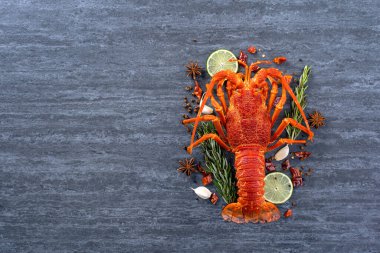 Pişmiş ıstakoz, lezzetli deniz ürünleri seti, üzerinde bıçak ve çatal olan siyah taş kaplama arka plan, restoran menüsü tasarımı, üst manzara, genel giderler.