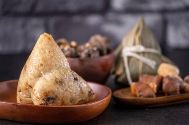 Pirinç köftesi, zongzi - Çin pirinçli hamur tatlısı siyah tuğlalı arka plan masa, Ejderha Teknesi Festivali konsepti geleneksel yemek, kapatın.