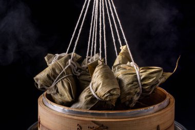 Pirinç köftesi, zongzi - Ejderha Teknesi Festivali, Çin geleneksel buharlı yemekler ahşap masa üzerinde siyah arkaplan üzerinde, yakın plan, kopyalama alanı