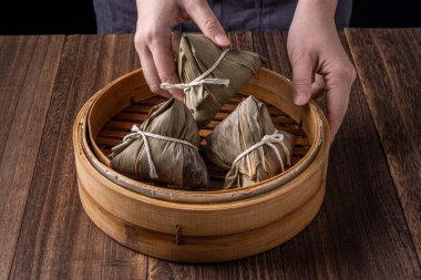 Pirinç köftesi, zongzi - Ejderha Teknesi Festivali, Çin geleneksel buharlı yemekler ahşap masa üzerinde siyah arkaplan üzerinde, yakın plan, kopyalama alanı