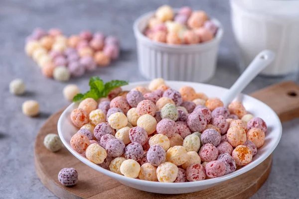 Colorful cereal corn balls mix, fruit flavor bowl sweets on gray cement background, close up, fresh, delicious and healthy breakbast, copy space design concept.