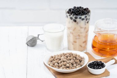 Muhallebi sütü çaylı tapyoka inci malzemeli, Tayvan içkisi beyaz ahşap masa zemininde içme bardağı, kapat, boşluğu kopyala