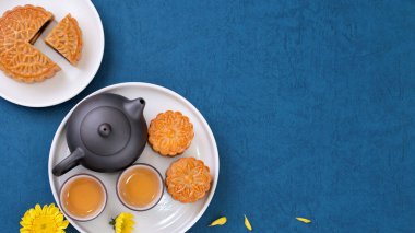 Sonbahar ortası festivali için mavi zemin üzerinde asgari sadelik düzeni ay pastaları, yaratıcı gıda tasarım konsepti, üst görünüm, düzlük, kopyalama alanı.