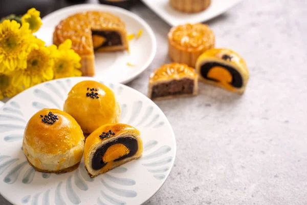 Tasty baked egg yolk pastry moon cake for Mid-Autumn Festival on bright cement table background. Chinese traditional food concept, close up, copy space.