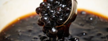Pişirme, kaynamış kahverengi şeker aromalı tapyoka inci topları, balonlu çayın içeriği, yemek ve içecek hazırlama, yakın plan, yemek kitabı adımları tasarımı konsepti.