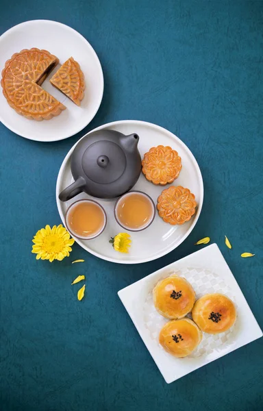 Moon cake for Mid-Autumn Festival, delicious beautiful fresh mooncake on a plate over blue background table, top view, flat lay layout design concept.