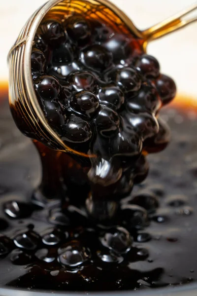 Pişirme, kaynamış kahverengi şeker aromalı tapyoka inci topları, balonlu çayın içeriği, yemek ve içecek hazırlama, yakın plan, yemek kitabı adımları tasarımı konsepti.