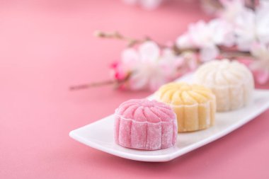 Colorful snow skin moon cake, sweet snowy mooncake, traditional savory dessert for Mid-Autumn Festival on pastel pale pink background, close up, lifestyle. clipart