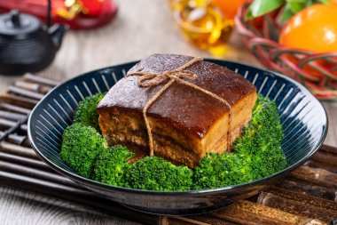 Dong Po Rou (Dongpo pork meat) in a beautiful blue plate with green broccoli vegetable, traditional festive food for Chinese new year cuisine meal, close up. clipart