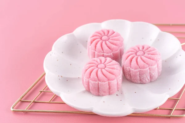 stock image Colorful snow skin moon cake, sweet snowy mooncake, traditional savory dessert for Mid-Autumn Festival on pastel pale pink background, close up, lifestyle.