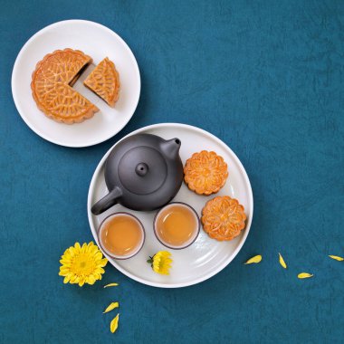 Sonbahar ortası festivali için ay çöreği, mavi arkaplan masasında bir tabakta lezzetli taze ay pastası, üst manzara, düz dizayn konsepti..