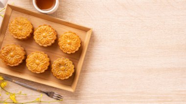 Sonbahar ortası festivali konsepti ay pastası, ay çöreği, parlak ahşap masa üzerindeki çay seti fotokopi alanı, üst görünüm, düz görünüm, genel çekim