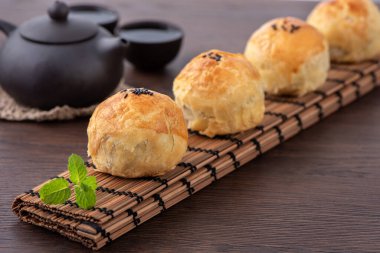 Ay pastası sarısı pastası, Sonbahar Bayramı tatili için ay çöreği, koyu ahşap masa arka planında tasarım konsepti.