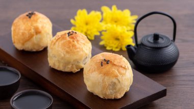 Ay pastası sarısı pastası, Sonbahar Bayramı tatili için ay çöreği, koyu ahşap masa arka planında tasarım konsepti.