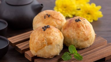 Ay pastası sarısı pastası, Sonbahar Bayramı tatili için ay çöreği, koyu ahşap masa arka planında tasarım konsepti.