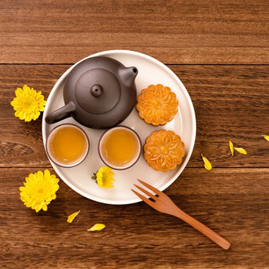 Sonbahar ortası festivali için ay pastası, koyu ahşap bir arka plan masasının üzerindeki tabakta nefis taze ay pastası, üst manzara, düz dizayn konsepti..