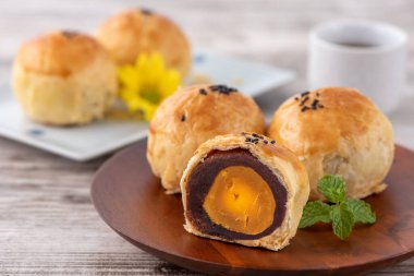 Ay pastası sarısı pastası, Sonbahar Festivali tatili için ay çöreği, fotokopi alanı olan parlak ahşap masa üzerinde üst görünüm tasarım konsepti.