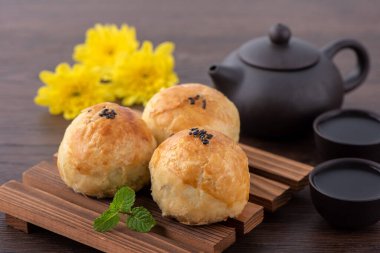 Ay pastası sarısı pastası, Sonbahar Festivali 'nin ortası için ay çöreği, fotokopi alanı, düz yatay, genel teması olan koyu ahşap masa üzerinde üst görünüm tasarım konsepti.