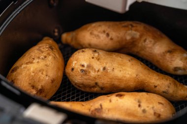 Kızarmış tatlı patates evde kızartma makinesi tarafından pişiriliyor. Diyet yemek için sağlıklı yiyecekler.