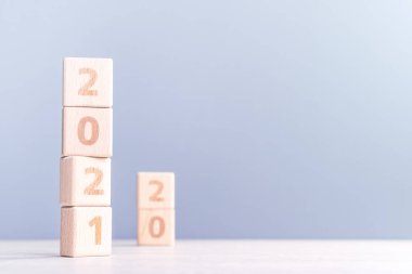 2021 Yeni Yıl Soyut Tasarım Konsepti - Ahşap masa üzerinde izole edilmiş tahta blok küpleri ve açık mavi arka plan.