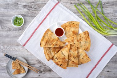 Tayvan yemeği. Parlak ahşap masa arkaplanında leziz pullu gözleme. Tayvan 'da geleneksel atıştırmalıklar..