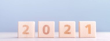 2021 Yeni Yıl Soyut Tasarım Konsepti - Ahşap masa üzerinde izole edilmiş tahta blok küpleri ve açık mavi arka plan.