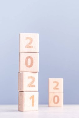2021 Yeni Yıl Soyut Tasarım Konsepti - Ahşap masa üzerinde izole edilmiş tahta blok küpleri ve açık mavi arka plan.