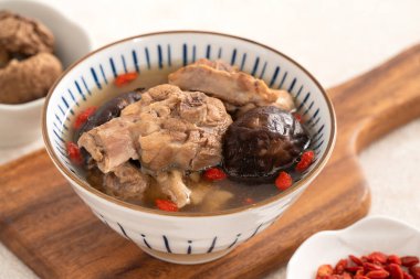 Lezzetli Tayvan şitaki mantarlı tavuk çorbası. Arka planda beyaz bir kasede..