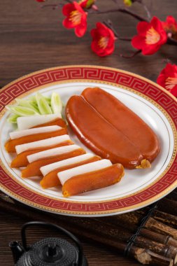 Delicious fresh mullet roe with white radish slices and garlic sprout for Chinese lunar new year gift basket box, holiday celebration.