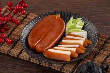Delicious fresh mullet roe with white radish slices and garlic sprout for Chinese lunar new year gift basket box, holiday celebration.