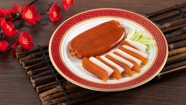 Delicious fresh mullet roe with white radish slices and garlic sprout for Chinese lunar new year gift basket box, holiday celebration.