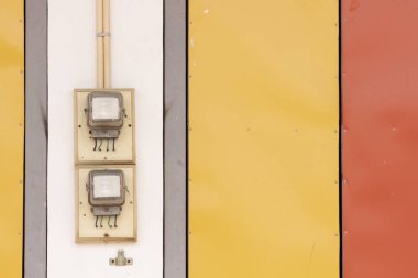 Renkli bir duvarda elektrik sayacı.