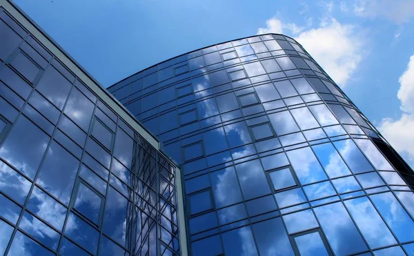 Clouds reflected in the many mirrored facets of a modern office building — Stock Photo, Image
