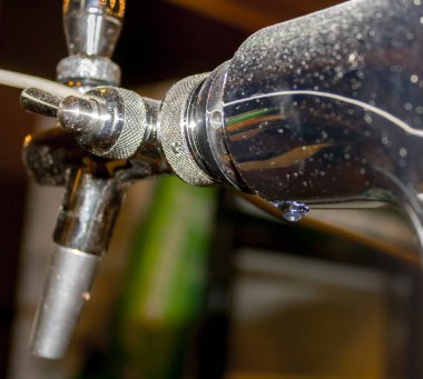 bira musluğunda asılı su damlası