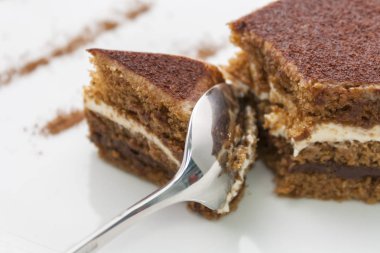 parlak bir kaşıkla bölünür lezzetli çikolatalı kek, bir parça; beyaz arka planda yakın çekim