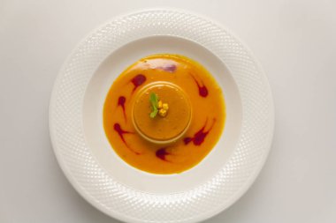 beyaz bir arka plan üst görünümünde beyaz bir tabak ta lüks bir restoranda nane ve deniz-buckthorn çilek bir sprig ile parlak turuncu cheesecake